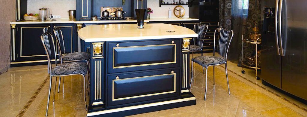 A beautiful kitchen with black cabinets and travertine tile flooring.