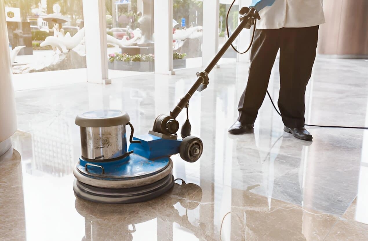 Professional technician using rotary floor polishing machine on commercial stone tile floor in Arizona